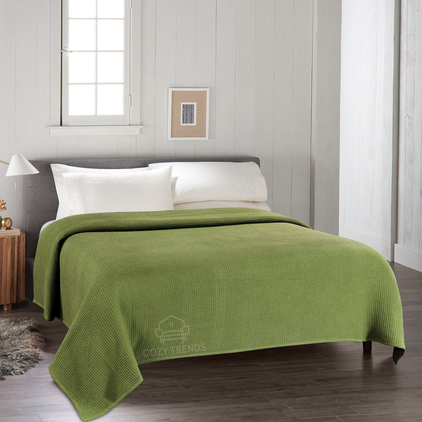 Green blanket on a bed in a bedroom with a neutral color scheme